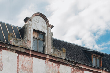 Crumbling Dormer and Weathered Roof of an Abandoned Historic Building