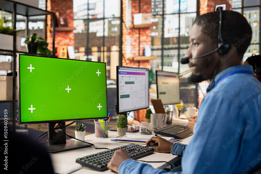 Poster call center worker in office solving customers issues using green screen pc. african american man in