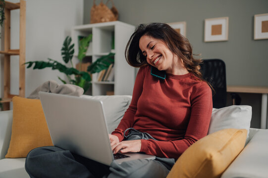 Happy freelancer working from home and talking on phone