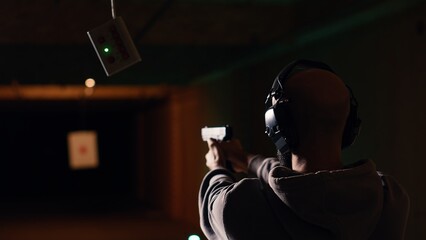 Company coworkers enjoying recreational shooting experience in firing range during teambuilding....