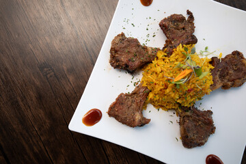 Lamb Chops with Yellow Rice on White plate