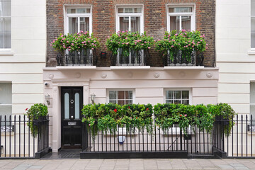 Elegant old London townhouse with planters on iron railing