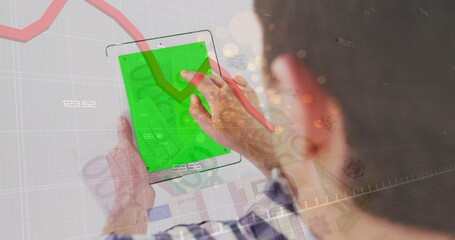 Red graph and sparks of light over caucasian man using digital tablet with copy space