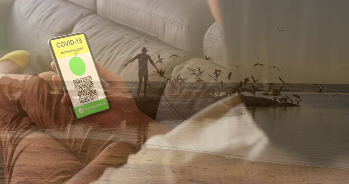 Image of caucasian woman with smartphone over caucasian man at beach