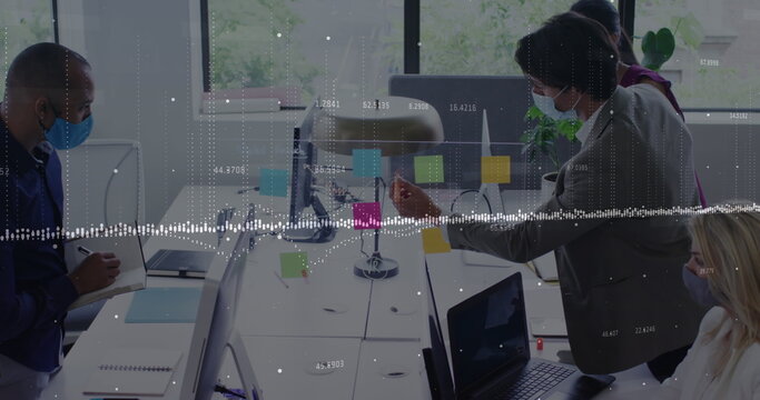 Data processing against diverse office colleagues wearing face masks discussing over memo notes
