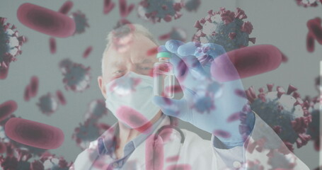 Fototapeta premium Image of virus cells over caucasian male doctor holding vial