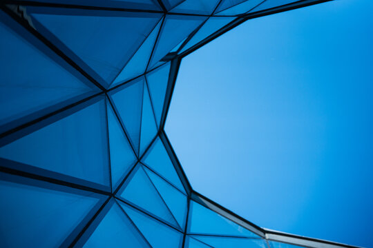 Contemporary architecture building with glass and metal facade on clear blue sky. For illustrating urban design or modern construction concepts. Copy space for text