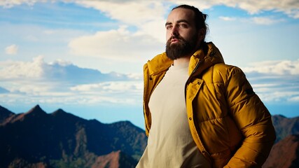 Determined climber gazes at the sky and rocky mountain tops, reflecting on the resilience and ambition needed to push beyond limits. Breathtaking skyline view inspires adventure. Camera A.