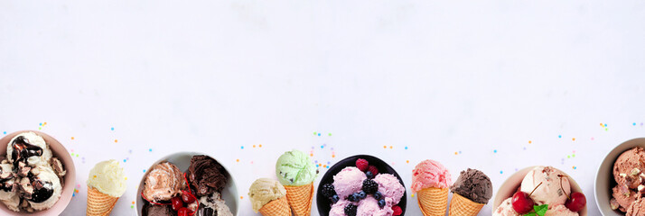 Summer ice cream bottom border. Bowls and cones of colorful assorted flavors. Top view on a white marble banner background. Copy space.
