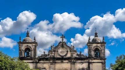 Fototapeta premium Ancient Church Facade Bells Blue Sky Clouds