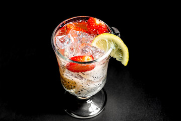 Cold refreshing cocktail with pitahaya and strawberries and garnished with a slice of lemon.