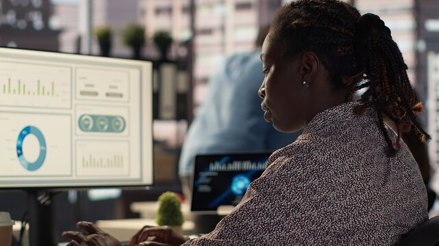 Female manager engaged in budget analysis and strategy development at her workstation, supporting objectives for company growth and collaboration. Strategizing business goals. Camera A.