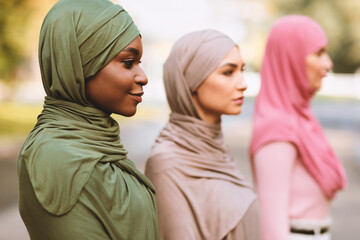 Three Diverse Muslim Women Posing Standing In Line And Looking Aside Outdoor, Wearing Traditional Hijab Headscarf. Selective Focus. Equality And Togetherness, Diversity Of Islamic Females