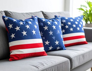 Three patriotic throw pillows on a gray couch.  American flag design on cushions, creating a festive, home decor scene