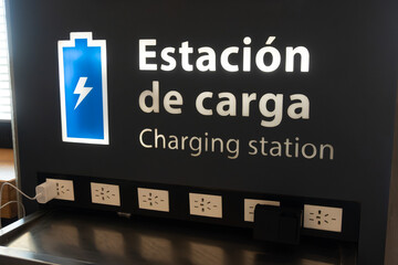 Airport device charging station features multiple power outlets and USB ports mounted on a dark...