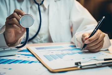Medical concept. Doctor Analyzing Health Data with Stethoscope and Pen in Medical Office Environment