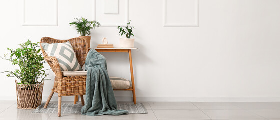 Interior of living room with wicker armchair, table and plants