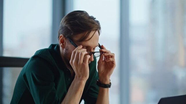 Pensive startuper thinking project taking off glasses at workplace closeup. 