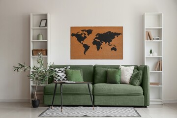 Green sofa, table, shelving units and world map on white wall in living room