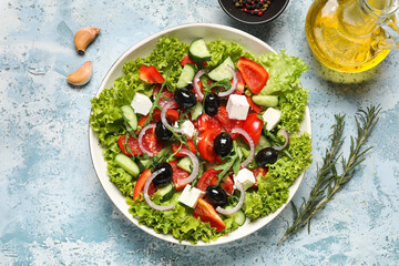Bowl of tasty Greek salad, spices and oil on color grunge background