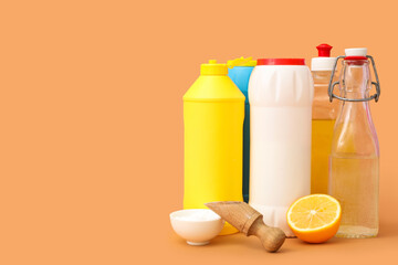 Set of cleaning supplies with baking soda and vinegar on orange background
