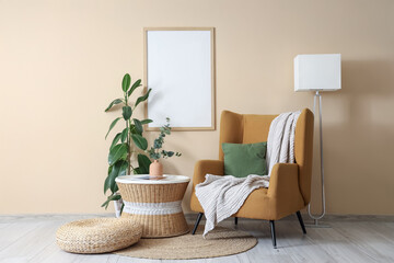Armchair, coffee table with eucalyptus in vase and ficus houseplant near beige wall in room