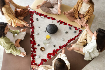Group of young girls meditating during women circle training, top view