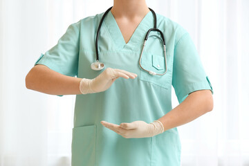 Female doctor showing something near light curtain, closeup