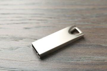 One flash drive on wooden background, closeup. Space for text