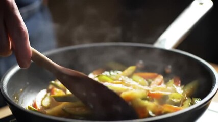 Adding salt to vegetables in a pan with a wooden spoon during cooking process - Powered by Adobe