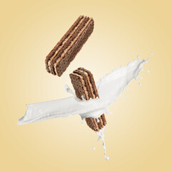 Tasty crispy wafers and splashing milk on dark beige background