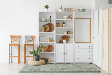 Fototapeta premium Interior of kitchen with closet, utensils and chairs