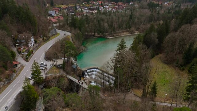 A breathtaking aerial view of Lechfall in Fussen, Germany. The turquoise waters cascade over the dam, surrounded by rugged cliffs and lush forests. A must-visit natural wonder in the Bavarian Alps