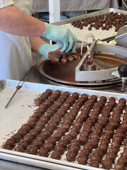 Confections chocolate factory workers preparing dipped Chocolate balls in Kitchen