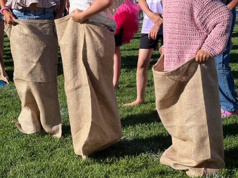 Unrecognizable children traditional potato sack race