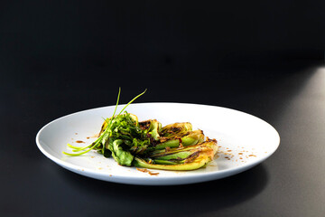Bok choy is artfully arranged on a plate, highlighting its vibrant green and charred textures.
