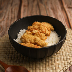 Rice bowl with chicken katsu and topped with sauce and sesame seeds