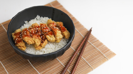 Rice bowl with chicken katsu and topped with sauce and sesame seeds
