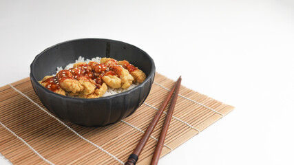 Rice bowl with chicken katsu and topped with sauce and sesame seeds