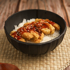 Rice bowl with chicken katsu and topped with sauce and sesame seeds