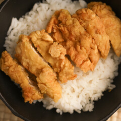 Rice bowl with chicken katsu and topped with sauce and sesame seeds