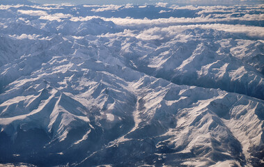 Caucasus mountains with snow peaks in aerial winter scene. Aerial view from plane.