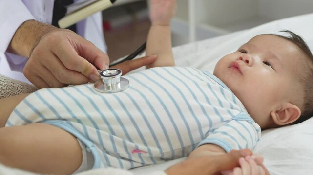 Asian loving mother comforts her three-month-old, as a male doctor administers essential childhood vaccinations, ensuring the baby's healthy future in a calm, professional setting.