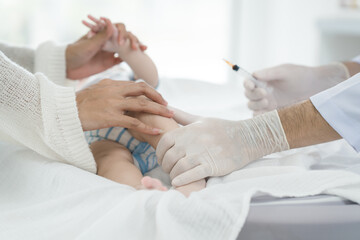 Asian loving mother comforts her three-month-old, as a male doctor administers essential childhood vaccinations, ensuring the baby's healthy future in a calm, professional setting.