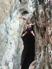 climber on the rock Female athlete top rope rock climbing at Railay Beach, Ao Nang, Krabi Province,...