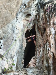 climber on the rock Female athlete top rope rock climbing at Railay Beach, Ao Nang, Krabi Province,...