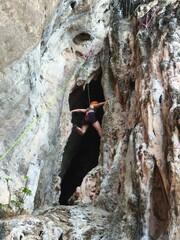 climber on a rock Female athlete top rope rock climbing at Railay Beach, Ao Nang, Krabi Province,...