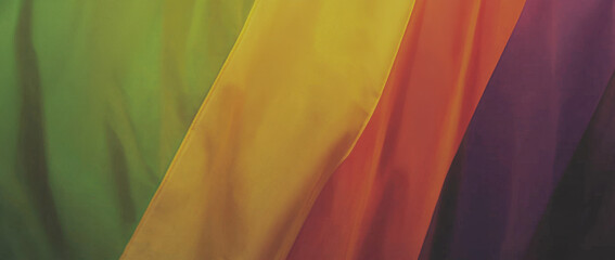 Vibrant rainbow fabric drapes in flowing manner, showcasing spectrum of colors including green, yellow, orange, red, and purple. silky texture adds sense of warmth and celebration