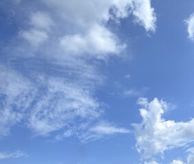 Fluffy clouds drift across azure sky