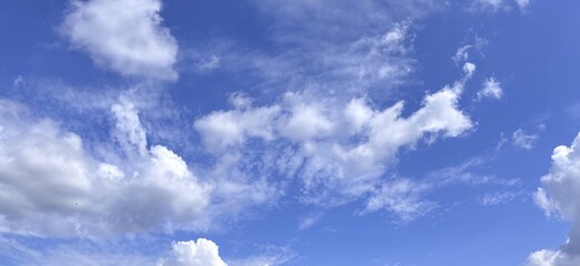Skys canvas Clouds dance in azure expanse